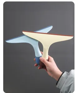 Mano che tiene due resistenti tergipavimento in silicone blu e beige per vetri e tavoli