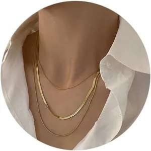 Detailed view of triple-layered gold chain necklaces on a white shirt background
