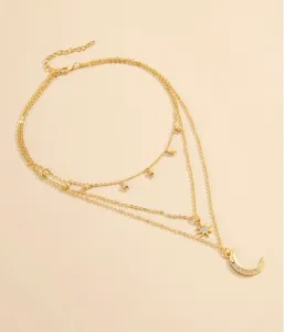 Dettaglio della delicata collana multistrato dorata con luna crescente e stella strass