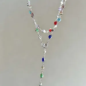 Detail view of a double-layered Y-shaped necklace with vibrant colorful crystals