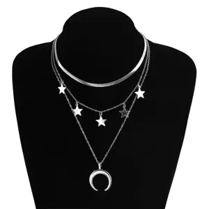 Gros plan d'un collier argenté multicouche avec des étoiles et un pendentif lune.