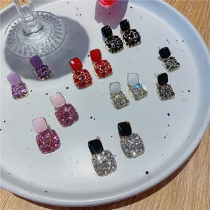 Macro detail showing colorful square drip oil stud earrings with sparkling rhinestone crystals
