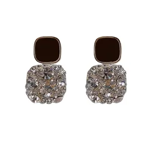 Detailed view of square stud earrings with black enamel top and full crystal cluster drop