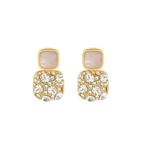 Detail shot of elegant gold earrings featuring pink enamel squares and full rhinestone pave