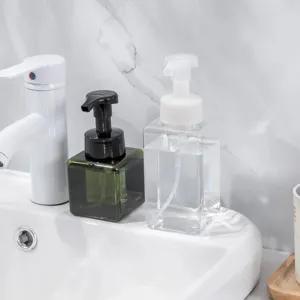 Set of two minimalist square foaming soap dispenser bottles on a white bathroom sink