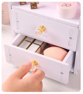 Primo piano del cassetto per trucco bianco con pomello in cristallo e spazio.