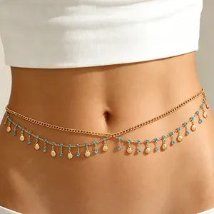 Close-up of elegant gold layered belly chain featuring blue rhinestones and shell fringe