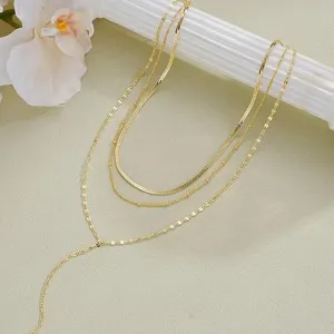 Élégant collier doré à plusieurs rangs avec long pendentif pompon sur support déco