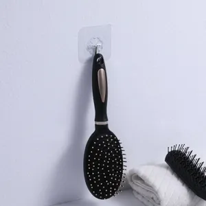 Anti-static black hairbrush hanging on wall hook in bathroom scene