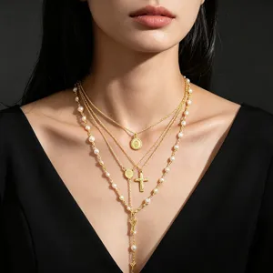 Detailed view of layered gold cross pendant necklaces with pearl accents on elegant model