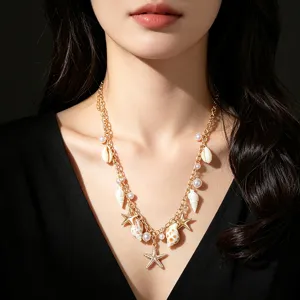Primo piano di collana a tema marino con stelle marine e perle indossata da modella.