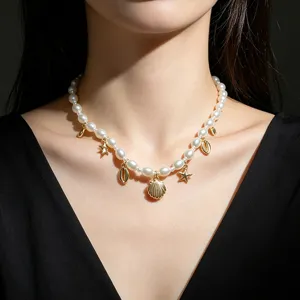 Elegante collana di perle con ciondoli dorati a forma di stella marina e conchiglia