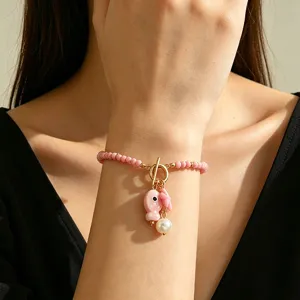 Detailed view of Bohemian pink beaded bracelet with ceramic spotted fish and pearl charms