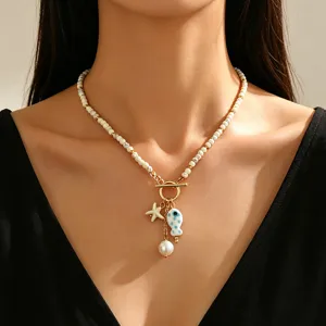 Bohemian necklace featuring ceramic fish, faux pearls, turquoise, and starfish charms.