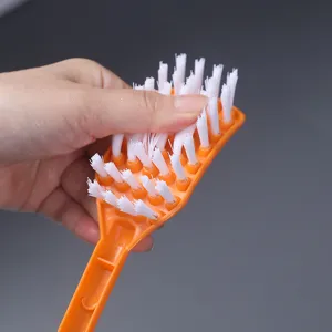 Orange plastic cleaning brush with flexible white bristles for toilet cleaning