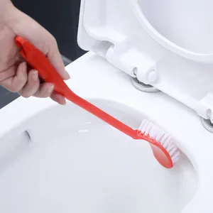 Red plastic toilet brush with long handle cleaning white toilet bowl rim