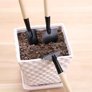 Kit de 3 mini outils de jardinage avec manches en bois disposés dans un pot blanc