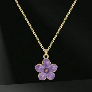 Vista dettagliata in primo piano della collana con ciondolo a fiore viola su catena oro.