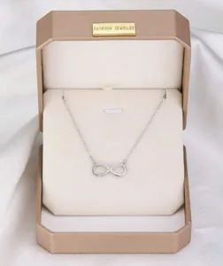 Elegante collar con colgante de infinito plateado presentado en una caja de regalo champán
