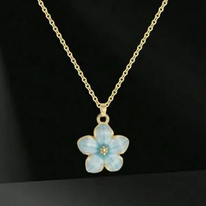 Deliziosa collana con ciondolo a fiore blu e catena d'oro, scatto di dettaglio per donna.