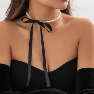 Elegant French vintage pearl choker necklace featuring a black velvet bow and silk gloves