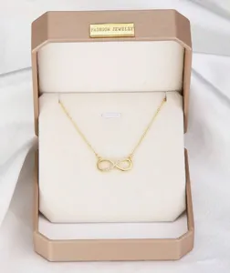 Collar con colgante de infinito dorado en una elegante caja de regalo de lujo