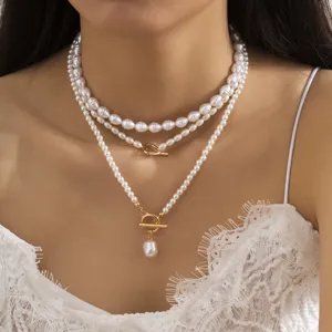 Primo piano di una collana di perle barocche a tre strati con una chiusura dorata