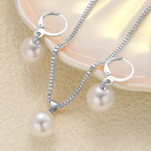Elegant white pearl necklace and leverback earrings set displayed on a cream shell