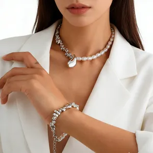 Close-up of elegant silver water drop necklace and matching pearl bracelet on a model.