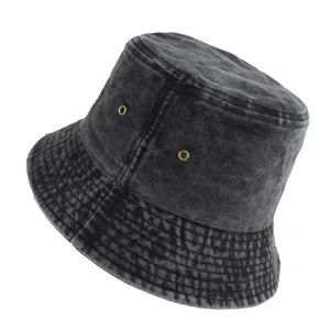 Detailed side view of washed grey denim bucket hat with metallic ventilation eyelets