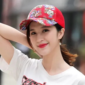 Detail shot of a woman wearing a red floral mesh baseball cap for outdoor sun protection.