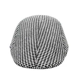 Close-up macro shot of classic black and white houndstooth pattern on wool flat cap