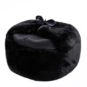 Vista detallada del sombrero de invierno negro de piel sintética con lazo de cinta decorativo