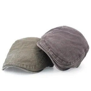 Two vintage washed cotton flat caps in green and grey colors on a plain white background
