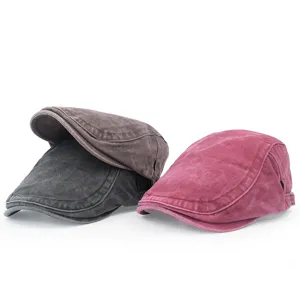 Macro view of vintage washed cotton newsboy beret caps in burgundy, grey, and brown colors