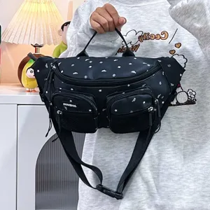 Detail view of a black star-patterned nylon waist bag for women in a casual setting