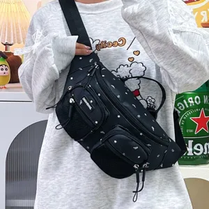 Close-up of a black nylon chest bag with star patterns worn by a model in a casual setting