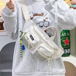 Close-up detail of a white nylon star-patterned chest bag worn by a model in a cozy indoor setting.