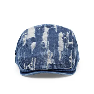 Detail of blue distressed denim flat cap with vintage ripped texture for a retro look.
