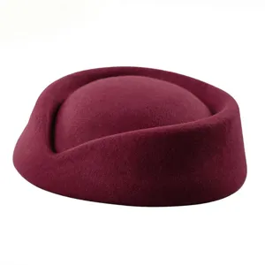 Close-up of a vintage burgundy wool felt pillbox hat for flight attendant style