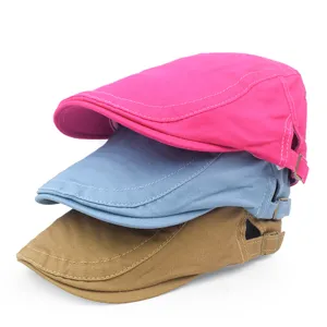 Stacked vintage cotton beret caps in pink, blue, and khaki showing texture and adjustable buckle.