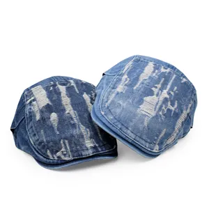 Detailed view of dark and light denim distressed newsboy caps with ripped finish.