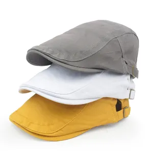 Stack of three vintage style cotton berets in grey, white, and yellow with adjustable straps