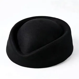 Detail of a vintage black wool pillbox hat showing smooth texture and structured shape.