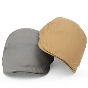 Close-up detail of vintage cotton flat caps in gray and khaki with precise stitching