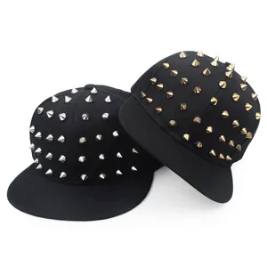 Detail view of black hip-hop snapback hats with gold and silver metallic spikes