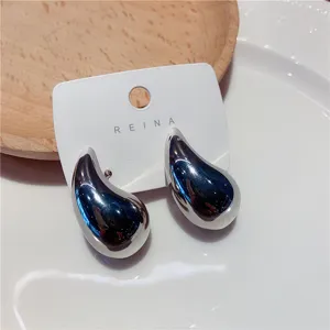 Gros plan de boucles d'oreilles clous argentées en forme de goutte avec fini poli