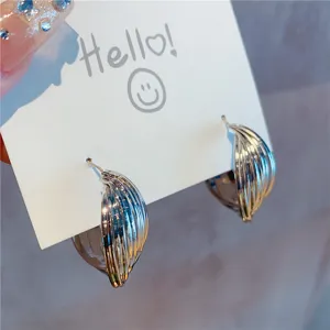 Detailed close-up view of the multi-layered metallic hoop earrings in a gold finish