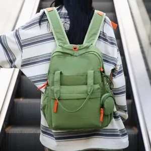 Vue détaillée d'un sac à dos de banlieue vert imperméable avec finitions orange vif.