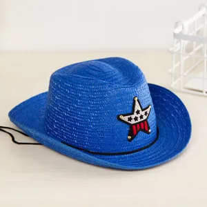 Détail d'un chapeau de cowboy en paille bleu pour enfant avec une décoration en forme d'étoile